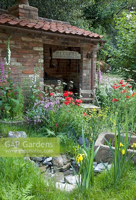The Old Forge Artisan Garden for Motor Neurone Disease Association. RHS Chelsea Flower Show 2015. Overview of garden with Wildflower planting 