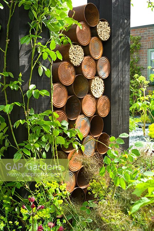  A contemporary sculpture of recycled rusty tin cans and insect homes. The RHS Great Chelsea Challenge Garden. 