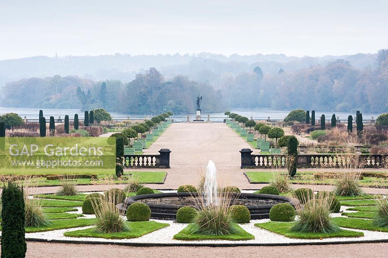 View across the Italian Garden towards the mile long Capability Brown lake. Includes fastigiate Irish yews, fountains, clipped Portuguese laurels, herbaceous perennials and grasses. Trentham Gardens