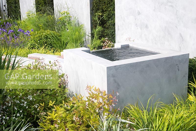 Square raised pond feeding rill. Plants include Gillenia trifoliata - The Scotty's Little Soldiers Garden, RHS Hampton Court Palace Flower Show 2015