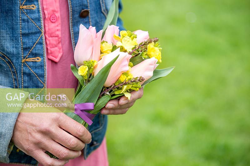 Woman holding Floral bouquet made with Tulipa 'Menton' and Cheiranthus cheiri 'Ivory White'