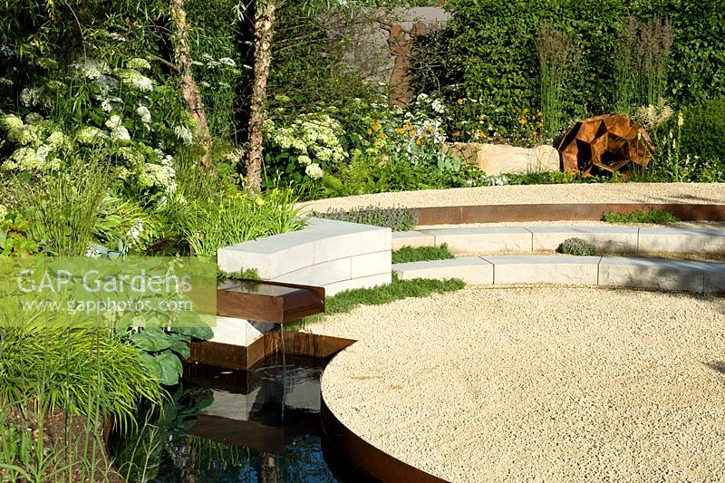 Successive levels in circular form with white stone-chip gravel, rusted-steel water spout and rill with border of white flowering hostas and hydrangeas with copper stems of birch ermanii. Vestra Wealth: Encore - A Music Lover's Garden Silver-Gilt RHS Hampton Court Palace Flower Show 2015medal 