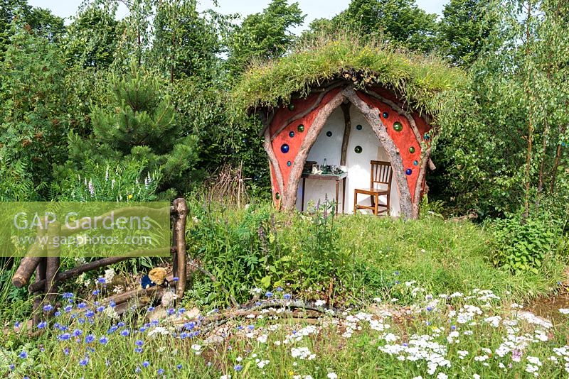 Botanica World Discoveries Garden. An imaginary woodland shelter where the author, A. A. Milne, wrote his Winnie the Pooh books. Designer: Anthea Guthrie. Hampton Court Flower Show 2015