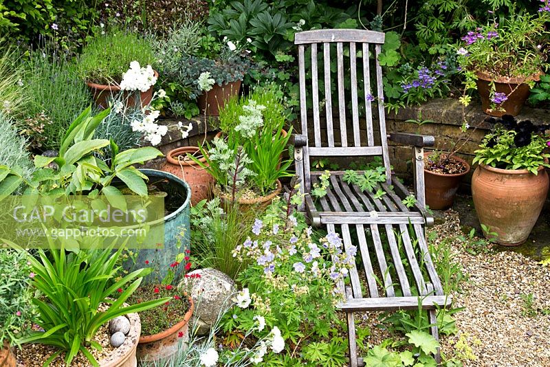 Wooden lounger surrounded by containers. Village of Fordcome, Kent - where a number of cottages opened up their gardens for the day.
