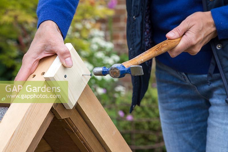 Woman adding a diamond shaped piece of wood to the front