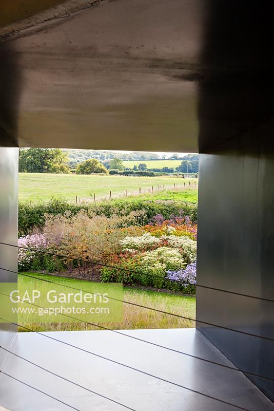 View onto the Oudolf Field from within the Ruddock Pavillion. Hauser and Wirth, Bruton, Somerset. Planting design by Piet Oudolf.