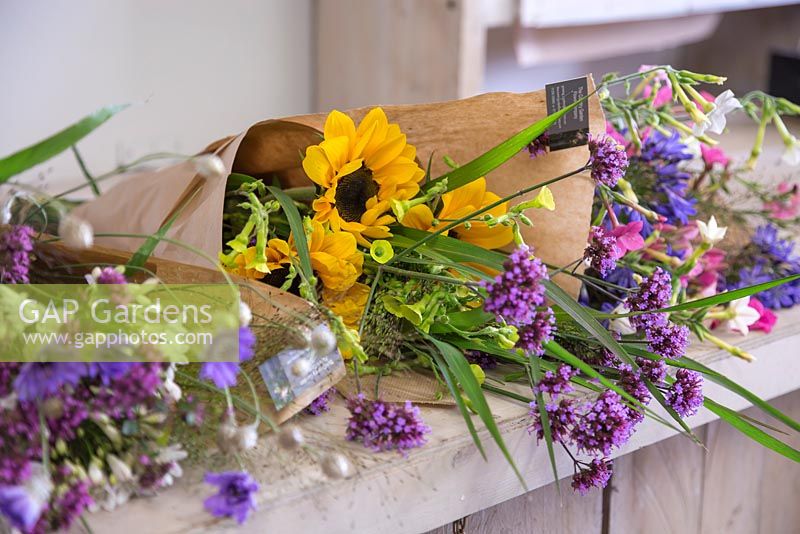Creating flower bunches for a farmers market. A variety of completed flower bundles on work surface