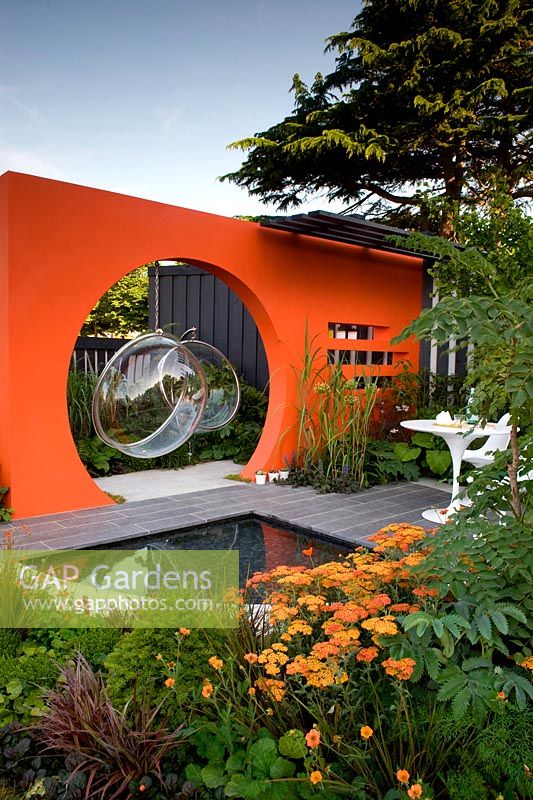 Creations Mid Century Modern - Best Low Cost High Impact Garden. RHS Hampton Court 2013. Orange moongate wall divider with pool. Design: Adele Ford and Susan Willmott Sponsor: Outdoor Creations
