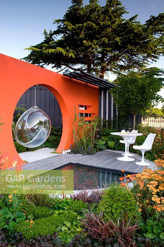 Creations Mid Century Modern - Best Low Cost High Impact Garden. RHS Hampton Court 2013. Orange moongate wall divider with pool. Design: Adele Ford and Susan Willmott Sponsor: Outdoor Creations
