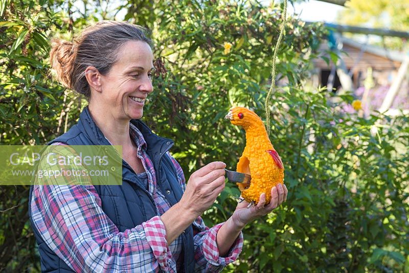 Woman filling Gourd Bird Feeder with seed