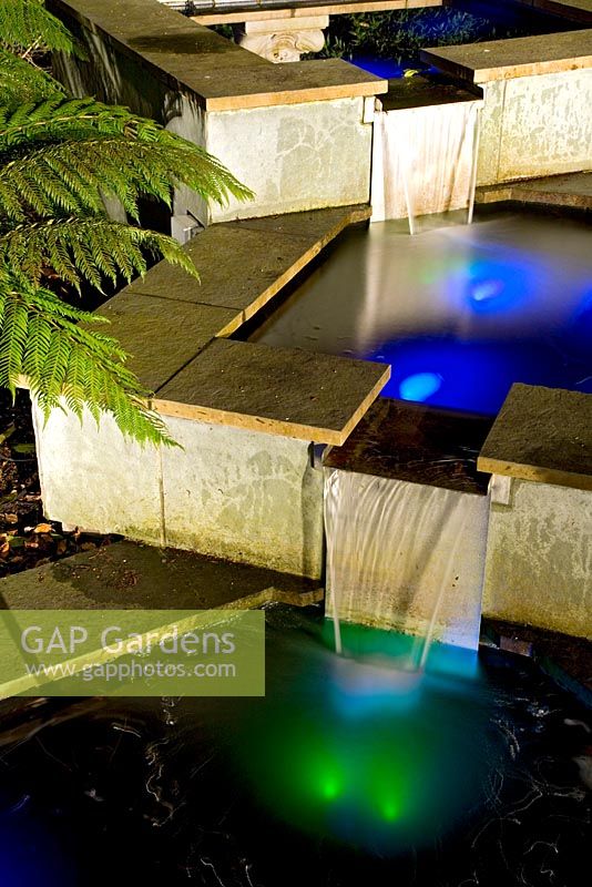 Lights reflecting in water feature at night
