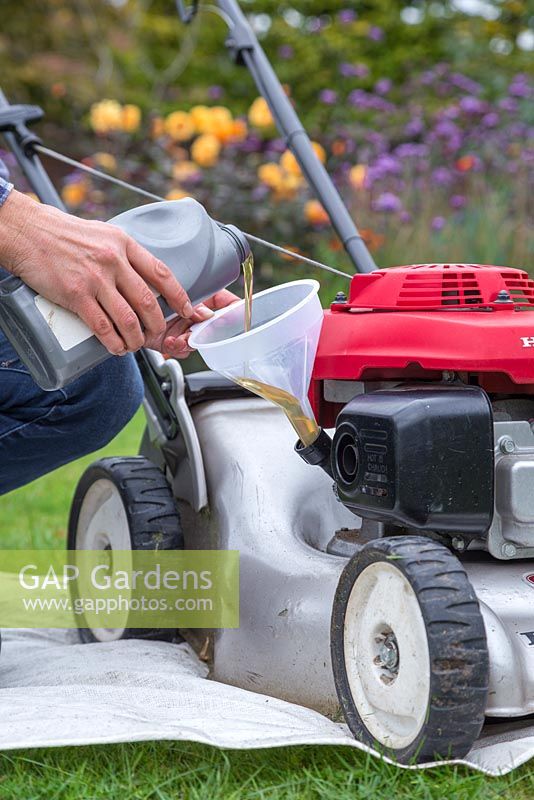 Whilst the lawn mower is upright, use a funnel to fill the lawn mower with new engine oil