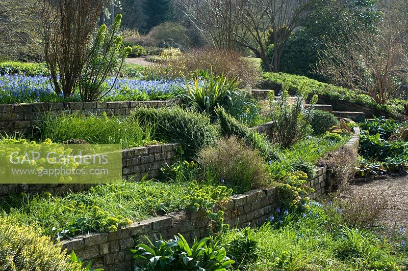 Large domestic country garden with terraced, brick raised beds 