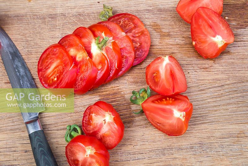Sliced Tomato 'Marmande' on wooden chopping board