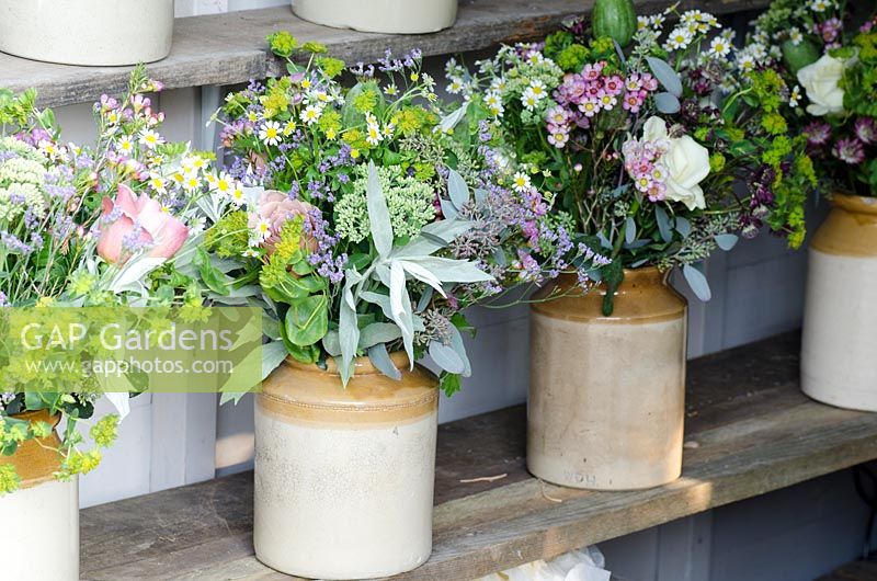 Cut flowers in stoneware jars including Sedum, Limonium platyphyllum - Sea lavender, Eucalyptus and Bupleurum rotundifolium