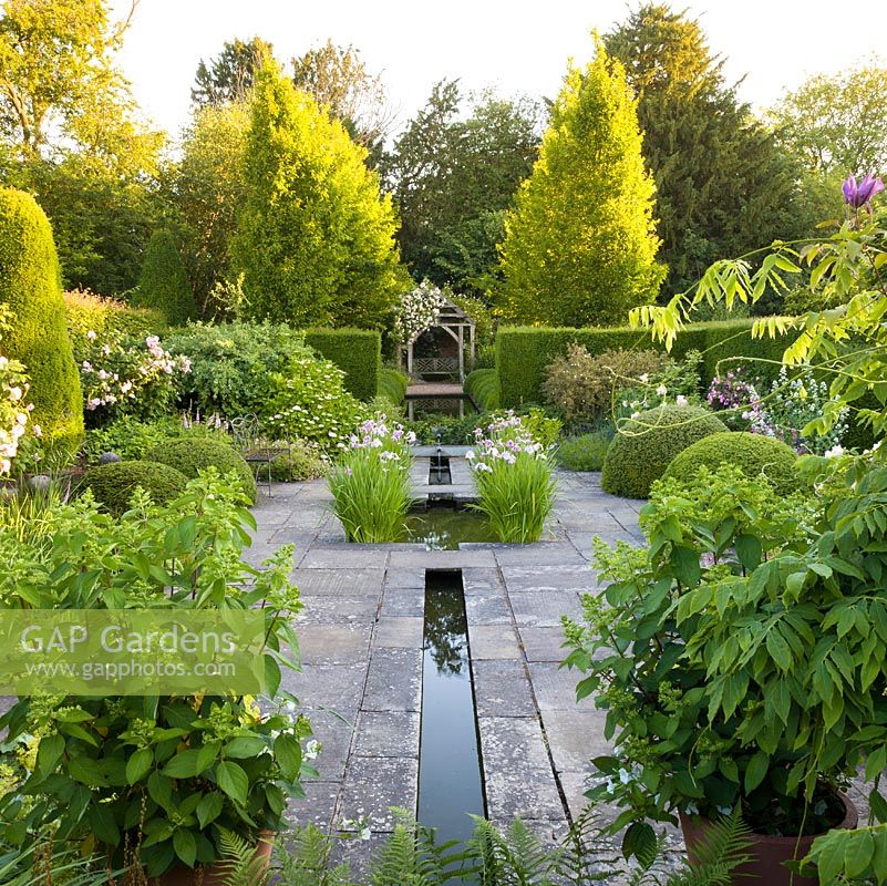 The Lower Rill Garden at Wollerton Old Hall Garden, Shropshire, planting includes Iris ensata, Hydrangeas, roses, Centranthus ruber 'Albus' and Salvias