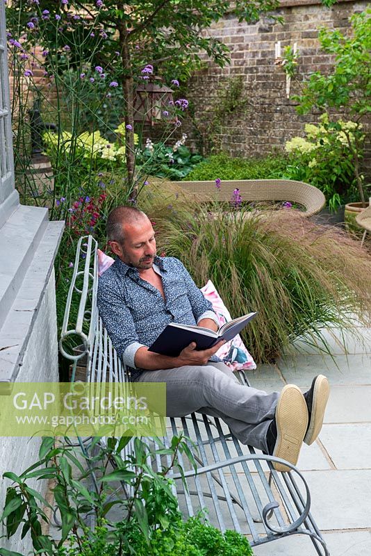 Derek Brewster relaxes in his small, irregularly shaped courtyard garden measuring 13m corner to corner, on the longest side.