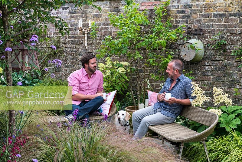 Derek Brewster and Nic Howard, garden designer, with Harry, the pet beagle, relax in their small, irregularly shaped courtyard garden measuring 13m corner to corner, on the longest side.
