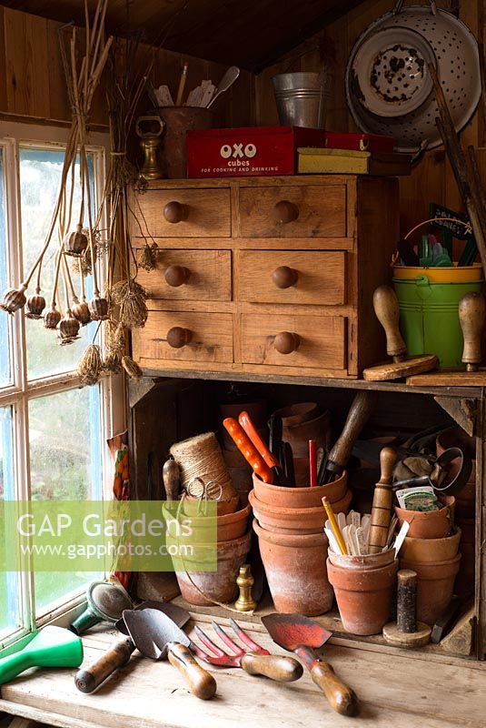 Traditional potting bench with an assortment of gardening items.