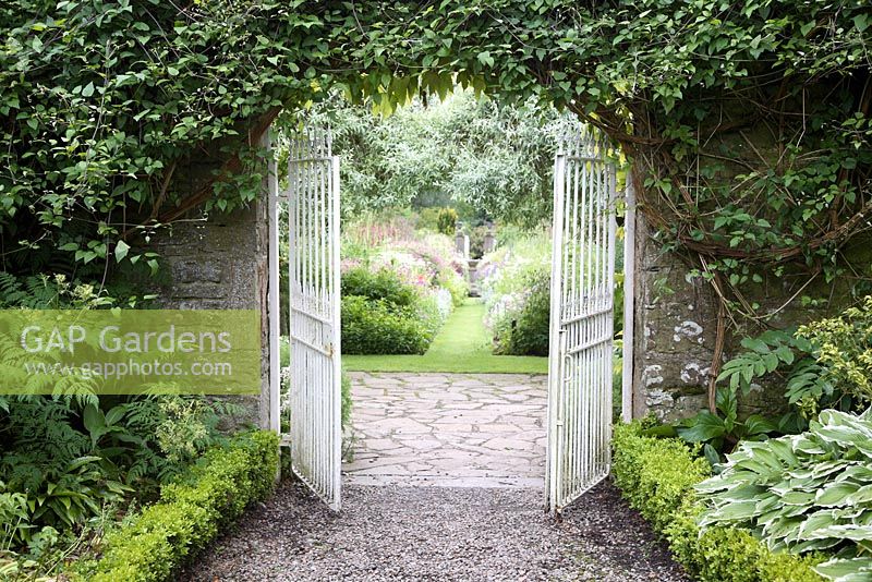 Iron gates leading to the perennial borders at Pitmuies Gardens, Scotland