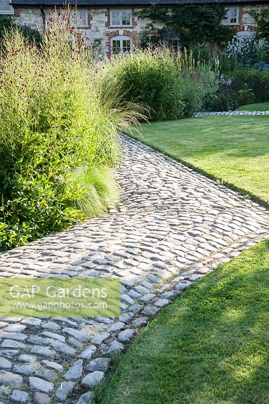 The Courtyard Garden designed by Piet Oudolf and John Coke features snaking cobble paths. Bury Court Barn, Bentley, Hants, UK
