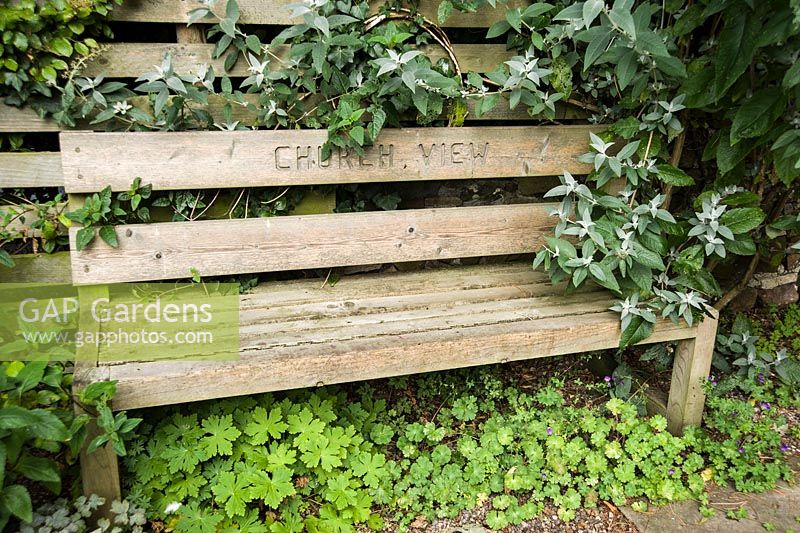 Bench with garden name carved into the back rest.
