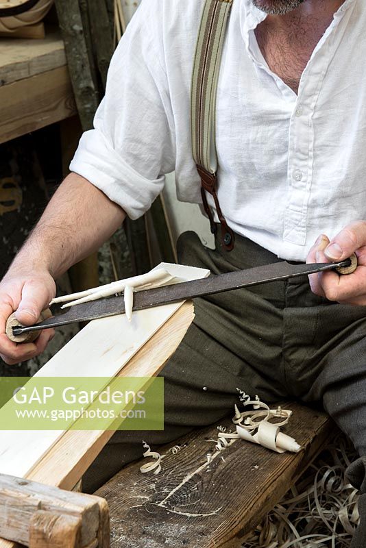 Charlie Groves making a traditional Sussex trug. Using a drawknife to shave willow boards thinner at either end, so they are flexible enough to press into the frame.