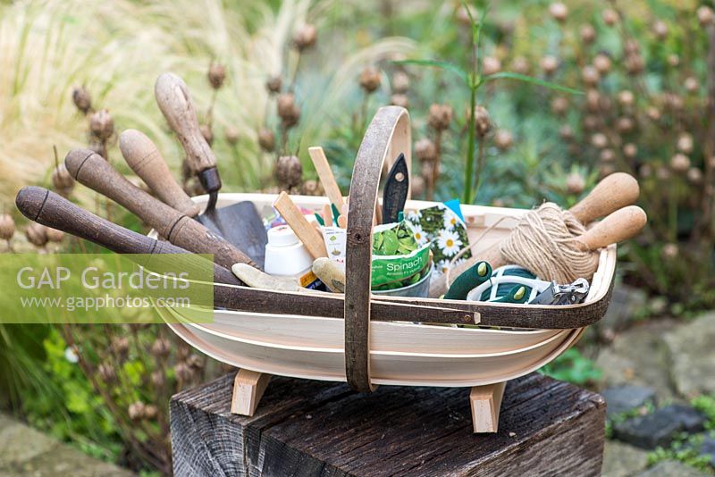 Seeds and planting tools in a traditional handmade Sussex trug made by Charlie Groves.