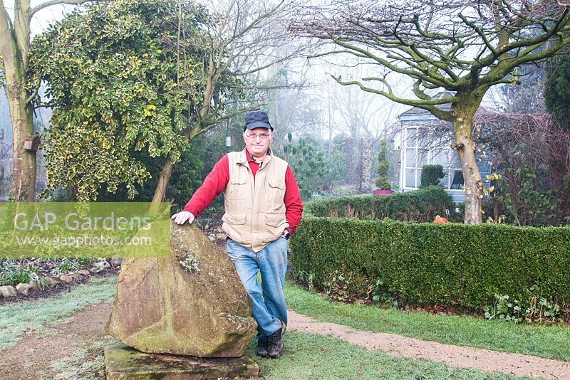 John Bent in his winter garden at 'Weeping Ash', Glazebury, Cheshire. February. The garden is open for the National Garden Scheme