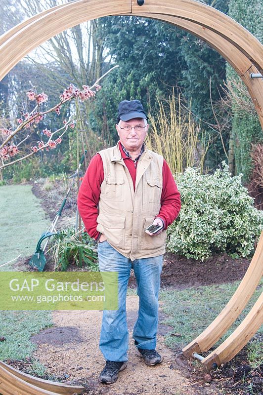 John Bent in his winter garden at 'Weeping Ash', Glazebury, Cheshire. February. The garden is open for the National Garden Scheme