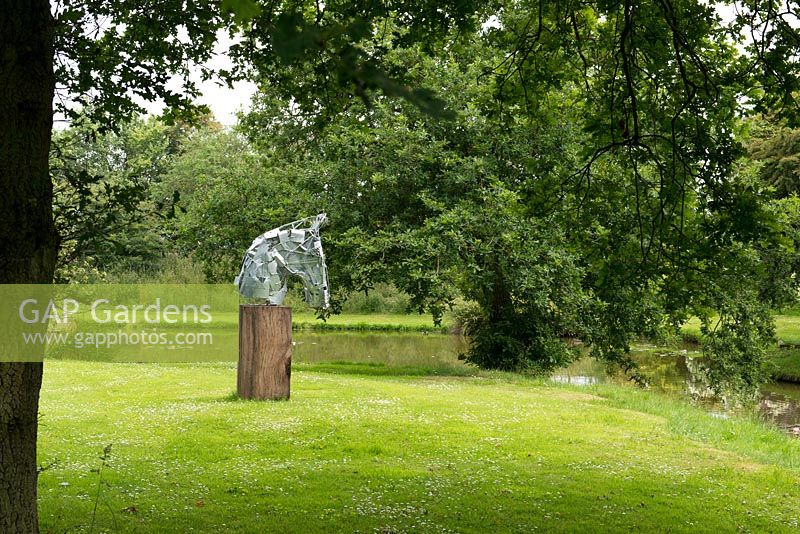 A horse head sculpture on a wooden plinth, by artist James Wild.