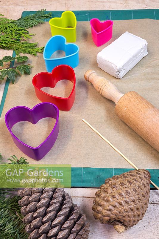 Materials required are a rolling pin, modelling clay, wooden skewer, heart shaped cutters and a variety of conifer foliage