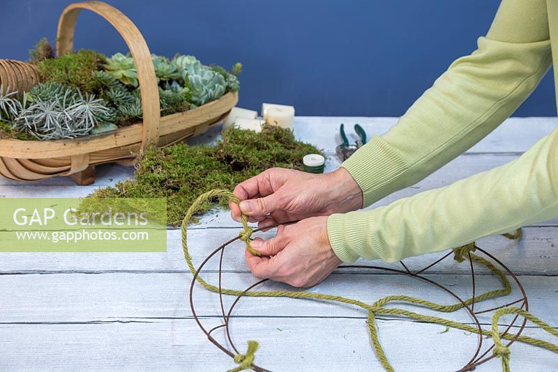 Tie the thick string to four corners of the wreath frame