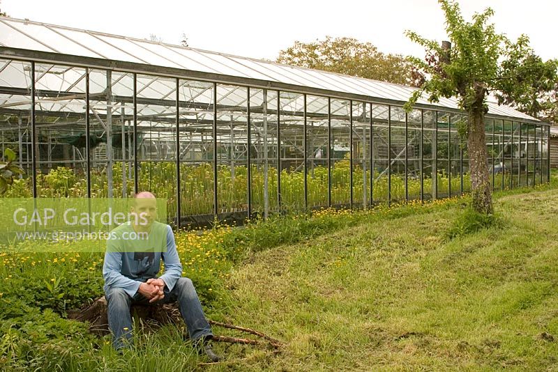 Nigel Hewitt-Cooper sitting outside greenhouse at Hewitt-Cooper Carnivorous Plants. 
