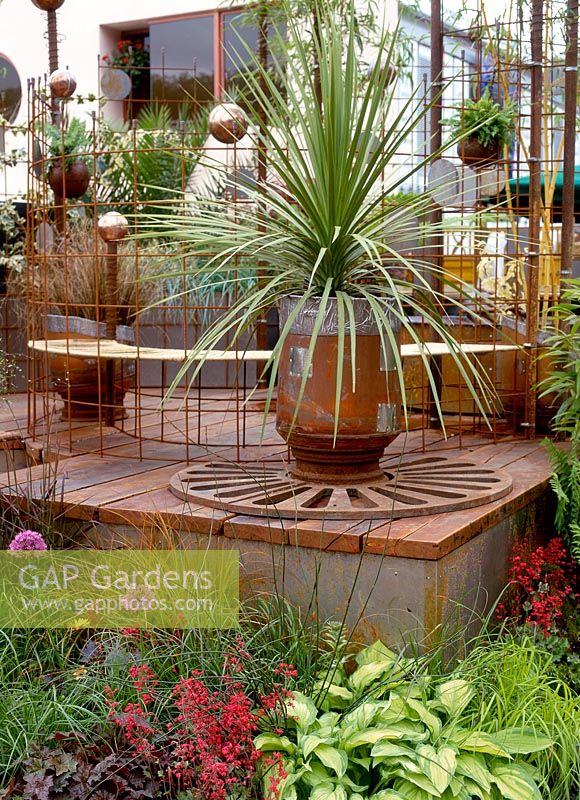 Cordyline growing in rusted container, Chelsea Flower Show 2002. The forgotten future. Design: Michelle Brown