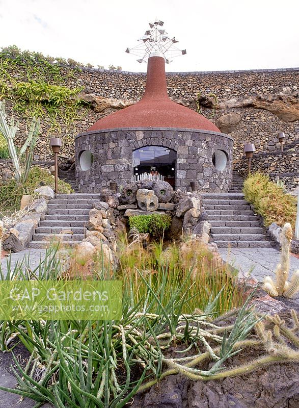 El Jardin cactus. Lanzarote, Shop built from volcanic rock with wind mobile on roof