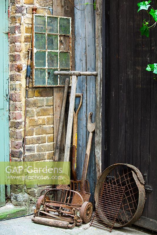Corner of the court yard with old garden tools, Lucille Lewins, small office court yard garden in Chiltern street studios, London. Designed by Adam Woolcott and Jonathan Smith