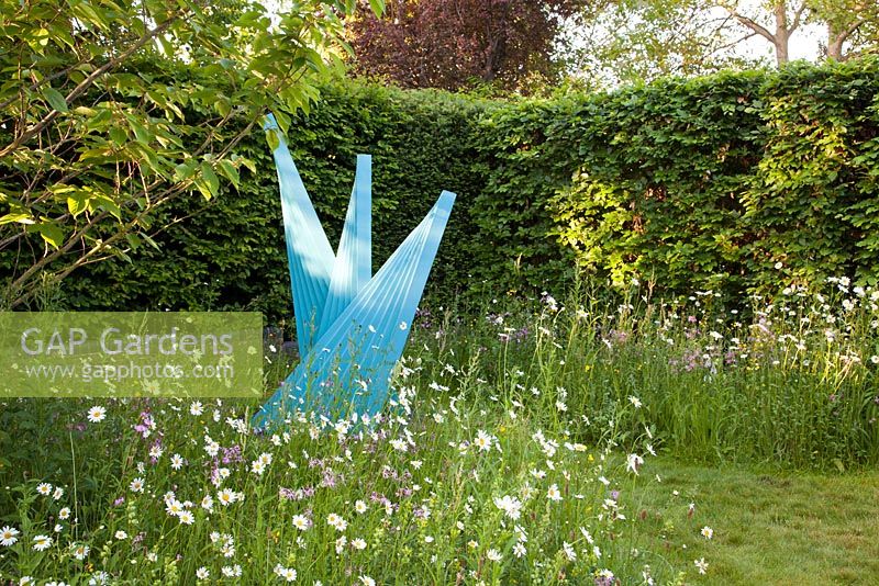 Contemporary sculpture by local artist Martin Cundall amongst wildflower planting of Ragged Robin Yellow Rattle, Lesser Knapweed, Red Campion and ox eye daisies 