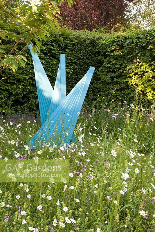 Contemporary sculpture by local artist Martin Cundall amongst wildflower planting of Ragged Robin Yellow Rattle, Lesser Knapweed, Red Campion and ox eye daisies

