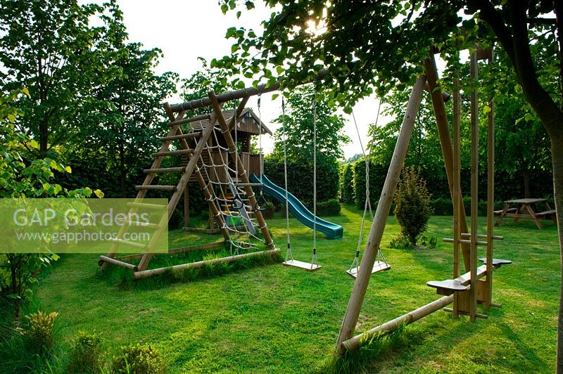 Childrens play area in a circular garden with hornbeam hedge boundaries 