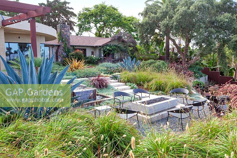 View of gas fired fire pit and outside seating. Debora Carl's garden, Encinitas, California, USA. August.