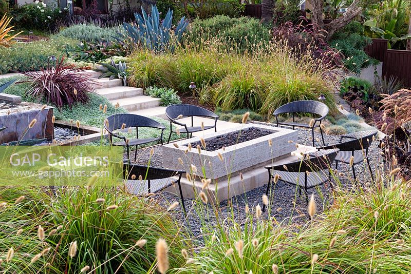 View of gas fired fire pit and outside seating. Debora Carl's garden, Encinitas, California, USA. August.