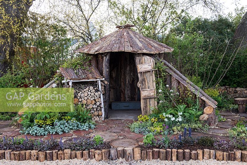 Wooden hut with log store - The Woodcutter's Garden, RHS Malvern Spring Festival 2016