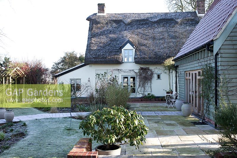 Thatched cottage with wooden extension on a frosty morning. St Francis Cottage