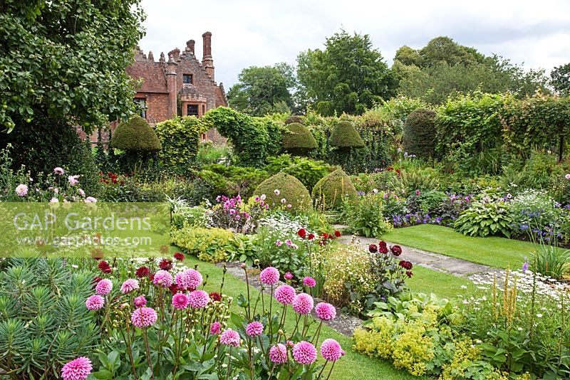 Chenies Manor 'Sunken Garden' - Showing double borders with Dahlia, Sisyrinchium, Petunia, Hosta, Geranium, Argyranthemum, Eryngium, Tanacetum parthenium, Rosa.  Chenies Manor Gardens, Bucks, UK
