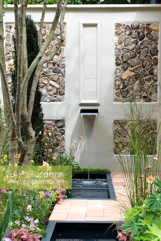 Water feature with pebble panelled wall. Pro Corda Trust - A Suffolk Retreat, RHS Chelsea Flower Show 2016 - Design: Frederic Whyte, Sponsor: Pro Corda Trust