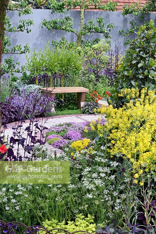 The St John's Hospice Garden, The Modern Apothecary.Oak bench in herb garden Designer: Jekka McVicar, RHS chelsea Flower show 2016