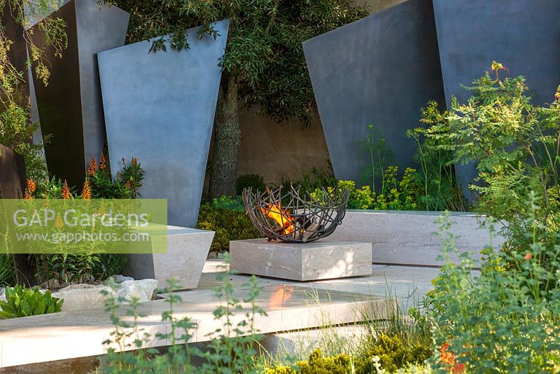 Dramatic bronze fins and firepit. The Telegraph Garden. RHS Chelsea Flower Show 2016. Designer: Andy Sturgeon - Sponsor: The Telegraph