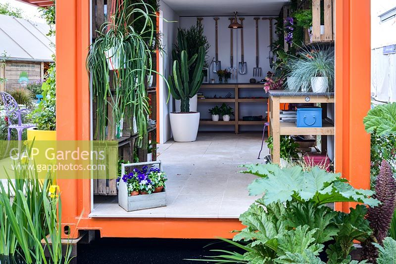 The Inside of a an orange shipping crate used as a potting shed at the RHS Greening Grey Britain for Health, Happiness and Horticulture Garden. RHS Chelsea Flower Show 2016 - Designer: Annie-Marie Powell