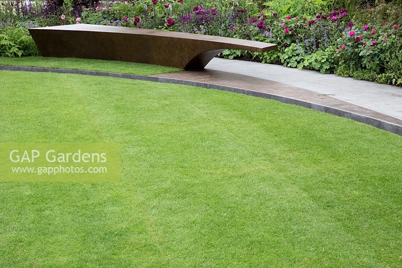 The Chelsea Barracks Garden, view of bronze bench, lawn, Basaltite stone path Rosa 'Nuits de Young'. RHS Chelsea Flower Show 2016, Designer: Jo Thompson, Sponsor: Quatari Diar